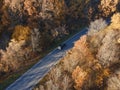 Rural road with black car in yellow and orange autumn fall forest. Aerial view Royalty Free Stock Photo