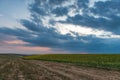 Rural road among farm fields at evening time Royalty Free Stock Photo