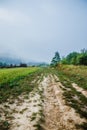 Rural road in a foggy morning on a big mountain. Foggy summer morning in the mountains and a small village. Country road in the Royalty Free Stock Photo