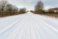 Rural road in the forest covered with snow. Travel on a snowy road on a winter day through the forest Royalty Free Stock Photo