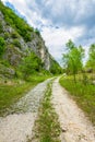 Rural road with grass, stones and cliffs Royalty Free Stock Photo