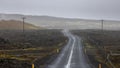 Rural road in Iceland through scenic black lava rock rugged terrain