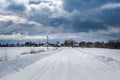 Rural road leading through the fields to the small village. Royalty Free Stock Photo