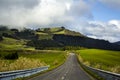 Rural road leading through green hills