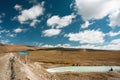 Rural road with mountain river and fishermen under white clouds blue sky Royalty Free Stock Photo