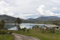 Rural road near to a country side house with green lake into a mountain rage valley Royalty Free Stock Photo