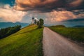 Rural road and Saint Primoz church at sunset, Slovenia Royalty Free Stock Photo