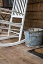 cigarette ash bucket sitting on a wooden porch in a rural setting with a rocking chair Royalty Free Stock Photo