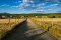 Rural scene of gravel road lined with barbed wire fences