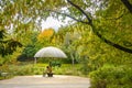 Rural scene at a pond with autumnal colorful trees and a bench that invites you to linger