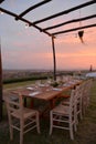 Dining outdoor in Italy. Decked table al fresco by sunset Royalty Free Stock Photo