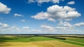 Rural scenic landscape with blue sky and clouds, green fields, yellow meadows in a summer sunny day. Panoramic view from Royalty Free Stock Photo