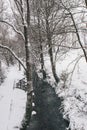Stream surrounded by trees and roads covered in snow during storm Emma. Royalty Free Stock Photo