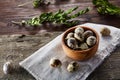 Rural still life with bowl full of eggs quail, eggs on a homespun napkin, boxwood on wooden background, top view Royalty Free Stock Photo