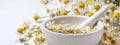 Rural still-life - chamomile crushed in a mortar on the background of a bouquet of daisies