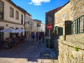 Rural street with stone houses, a red prohibitted signal and backpackers walking in Santiago de Compostela, Spain