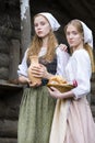 Rural Style Concepts. Two Young Beautful Caucasian Girlfriends in Traditional Rural Outfit Posing With Caly Jar And Bread