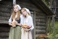 Rural Style Concepts. Two Young Beautful Caucasian Girlfriends in Traditional Rural Outfit Posing With Caly Jar And Bread