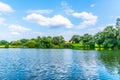 Rural summer landscape reflected in the pond. Blue sky, white clouds and lush green trees Royalty Free Stock Photo