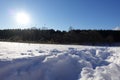 Rural winter landscape with a field snow and the blue sky. Low winter sun Royalty Free Stock Photo