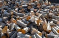 Rural wood storage of sawed tree trunks and a stack of firewood in a garden in sunny winter Royalty Free Stock Photo