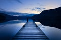 Wooden Jetty/Pier Leading Out To Calm Lake With Reflections At Blue Hour In The Lake District, UK Royalty Free Stock Photo