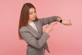 Rush, hurry up to come in time! Portrait of worried busy lady in business suit pointing to watch on her wrist