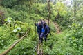 Porter helps guide a women tourist over a sketchy