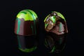 ÃÂ¡rushed handmade candy with green splach decoration and chocolate ganache and fruit jelly filling on black background Royalty Free Stock Photo