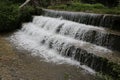 A rushing and deeply secluded stream flows through the lush vegetation of a southern forest