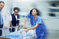 Rushing to the ER. Shot of a group of medical professionals rushing a patient on a gurney down a hospital corridor. Royalty Free Stock Photo