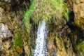 Rushing Waters Flowing with High Speed from a Waterfall. Water Flows through Steep and Mossy Rocks Royalty Free Stock Photo
