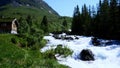 Rushing white water flowing rapidly from snow melting on the mountain in Norway. Beautiful rocky river roaring downhill.