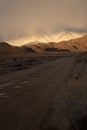 Russet color hills and snowy mountain shrouded in clouds Royalty Free Stock Photo