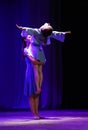 Two girls dancing modern dance. One supports the other in the form of crucifixion.