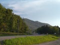Cars drive on the mountain road past the rocks in Altai beautiful landscape on the highway in Royalty Free Stock Photo