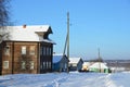 Russia, Arkhangelsk region, wooden buildings in the village Turchasovo in winter in sunny weather Royalty Free Stock Photo