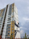 Russia, Chelyabinsk 08/03/2020 View of a house in a modern district of the city. On the wall, artists paint a picture,