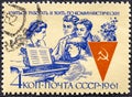 RUSSIA - CIRCA 1961: Stamp printed in the USSR shows workers around piano Publicizing communist labor teams in their Royalty Free Stock Photo