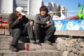 Russia, city of Magnitogorsk, - April, 18, 2015. Two homeless people are sitting on the steps near the childrens park