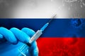 Russia Covid-19 Vaccination Campaign. Hand in a blue rubber glove holds a syringe with covid-19 virus vaccine in front of Russia Royalty Free Stock Photo