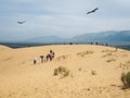 A group of tourists enjoy the views after climbing a sand dune