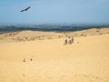 A group of tourists enjoy the views after climbing a sand dune