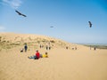 A group of tourists enjoy the views after climbing a sand dune