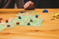 Russia, December 2020: two men friends have fun playing the carcassonne board game late in the evening or at night. male hands and Royalty Free Stock Photo