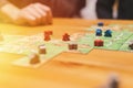 Russia, December 2020: two men friends have fun playing the carcassonne board game late in the evening or at night. male hands and Royalty Free Stock Photo