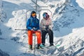 Russia, Dombai-February 7, 2017: Two skiers lift to the Ski Resort high in the winter snow mountains at chair cable car Royalty Free Stock Photo