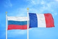 Russia and France two flags on flagpoles and blue cloudy sky Royalty Free Stock Photo