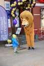 An animator in the costume of Alex the lion from the cartoon Madagascar