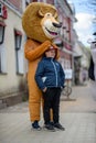 animator in the costume of Alex the lion from the cartoon Madagascar is photographed with children in the city